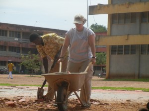 Crystal pushing the wheel barrow to help clear the old basketball court.