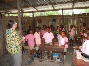 Crystal quizzing students about HIV/AIDS and handing out pencils. Ghana.